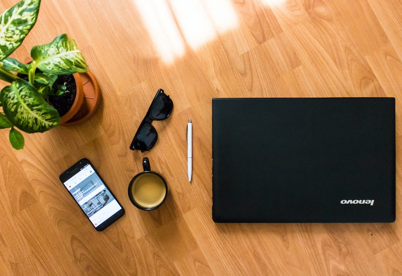 Laptop Beside Headphones and Camera